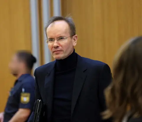 Braun, laptop under his arm, looks on from inside the courtroom as the trial begins