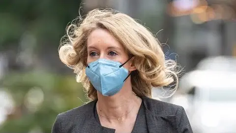 Holmes, masked, arriving at the San Jose federal courthouse; Bloomberg's report on the guilty verdict