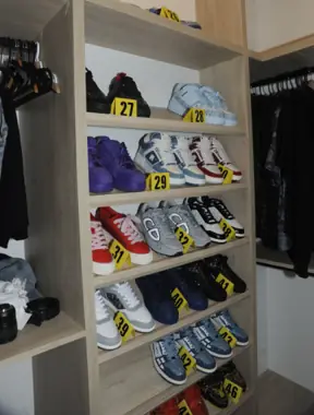 Inside the closet: rows of designer sneakers tagged with yellow evidence markers during the FBI search