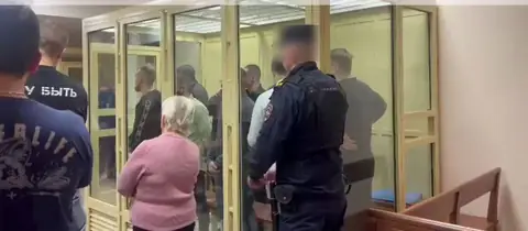 The defendants in the glass dock at the Moscow Regional Court as the Hydra verdict is read: Moiseyev to life, fifteen others to 8-23 years